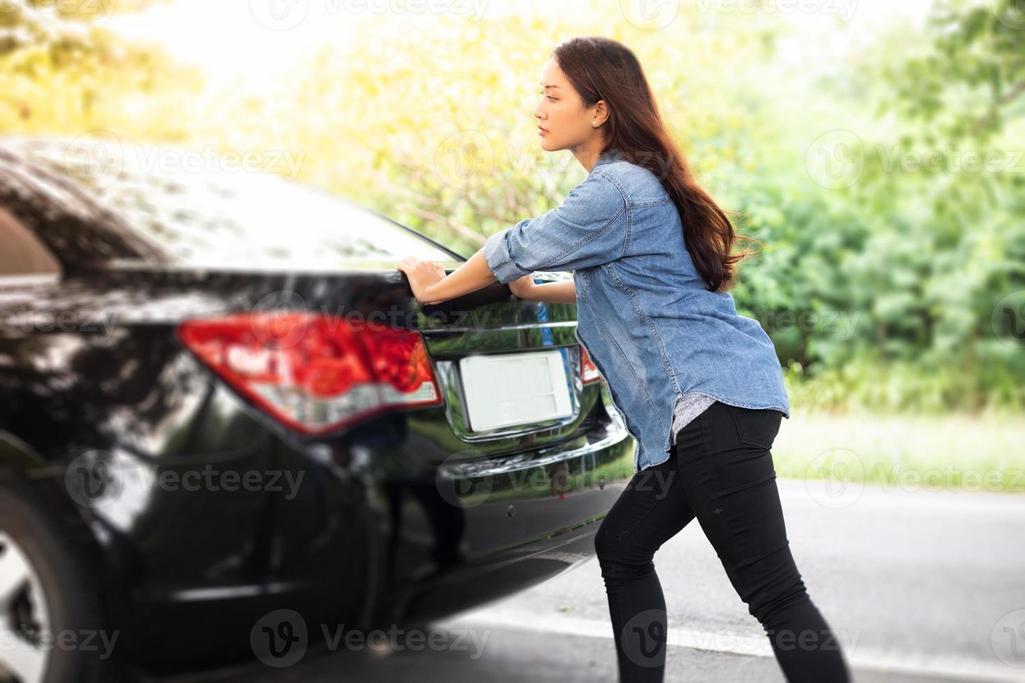 mulheres estressadas após uma quebra de carro com o triângulo vermelho de um carro na estrada foto