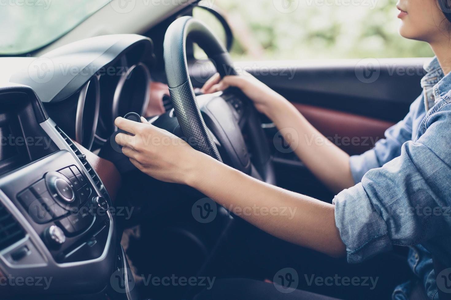 mãos da mulher asiática apertar o botão sinalizador, abotoar o carro, foco seletivo disponível foto