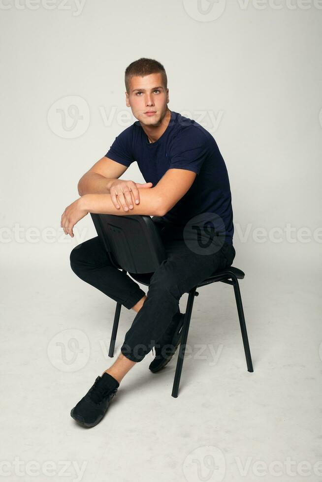 jovem moda homem sentado em uma cadeira foto
