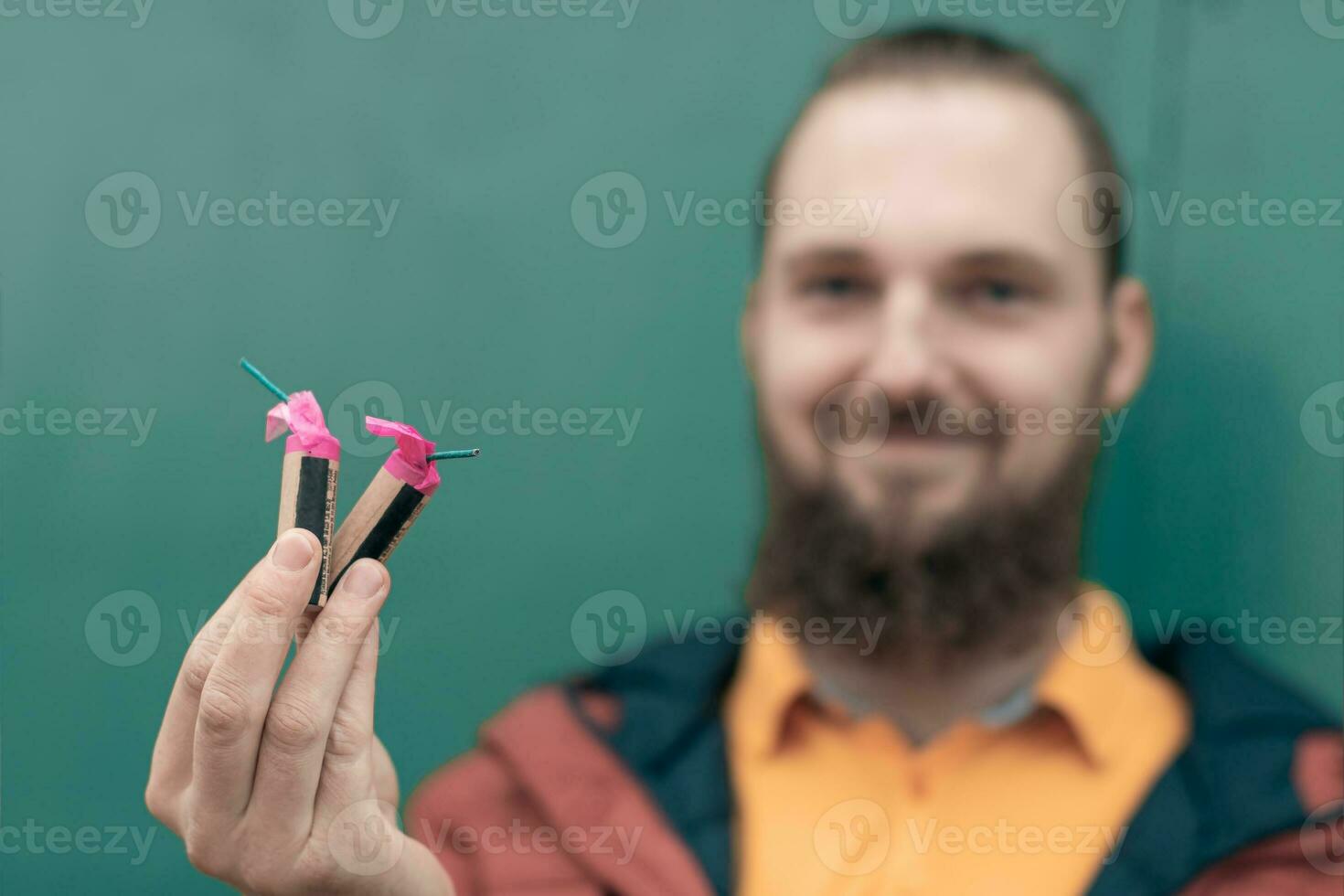 feliz jovem homem segurando fogos de artifício dentro dele mão. barbudo cara obtendo pronto para Novo ano Diversão foto