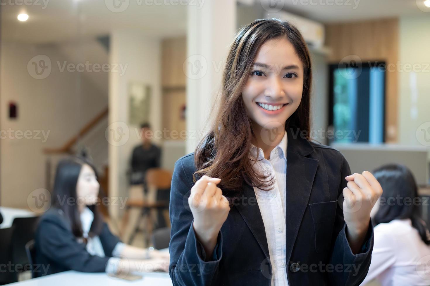 Sucesso e conceito vencedor de mulheres de negócios asiáticas - equipe feliz com as mãos levantadas celebrando o avanço e as conquistas foto