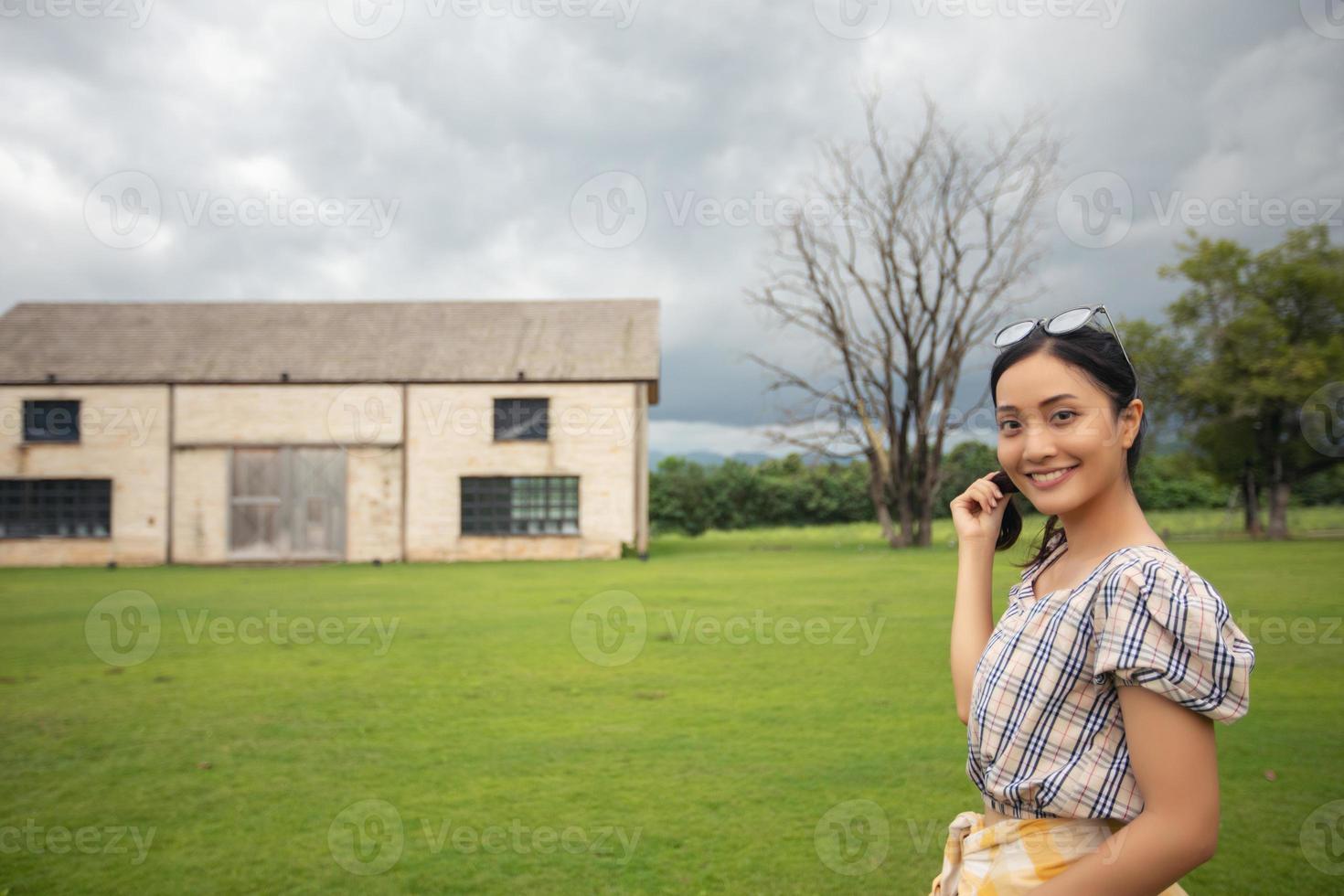 em pé mulher segurando e sorrindo feliz no parque. foto