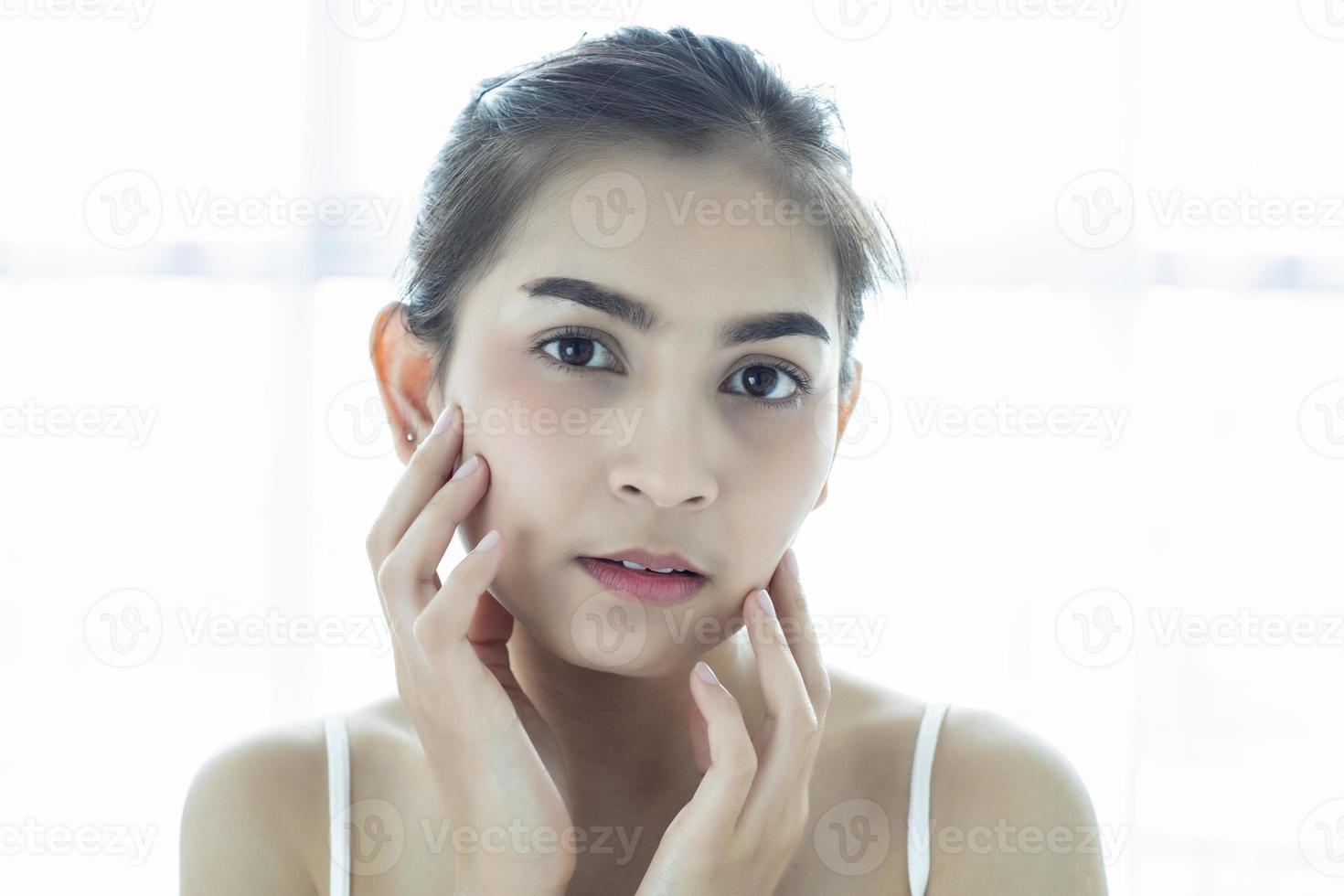 mulheres asiáticas lindas com pele limpa, fresca, tocam o próprio rosto. tratamento facial. cosmetologia, beleza e spa foto