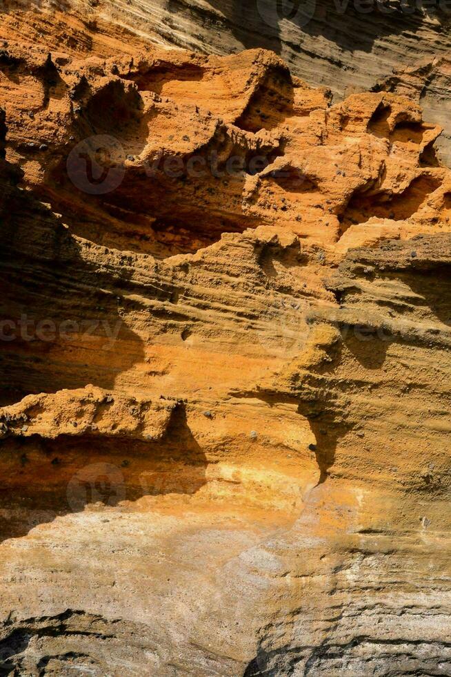 uma Rocha formação com laranja e Castanho cores foto