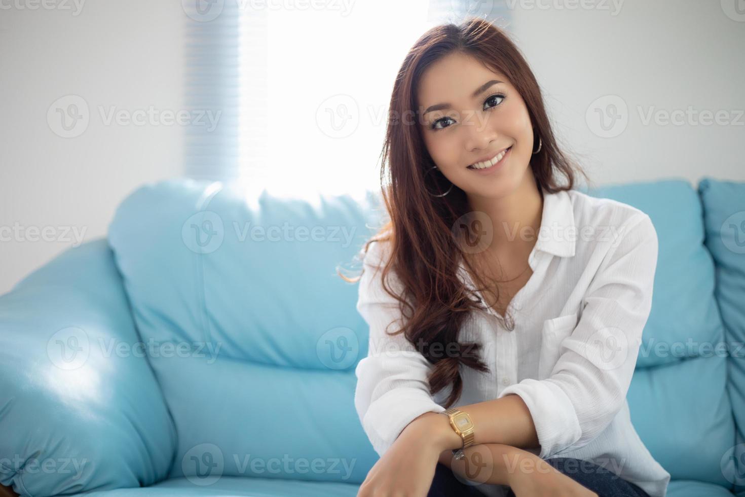 mulheres asiáticas sorrindo felizes por relaxar no sofá em casa foto