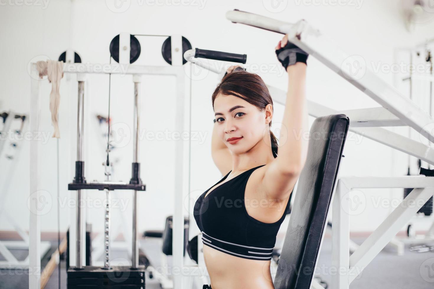 linda musculoso apto mulher exercitando construção de músculos e fitness mulher fazendo exercícios no ginásio. fitness - conceito de estilo de vida saudável foto