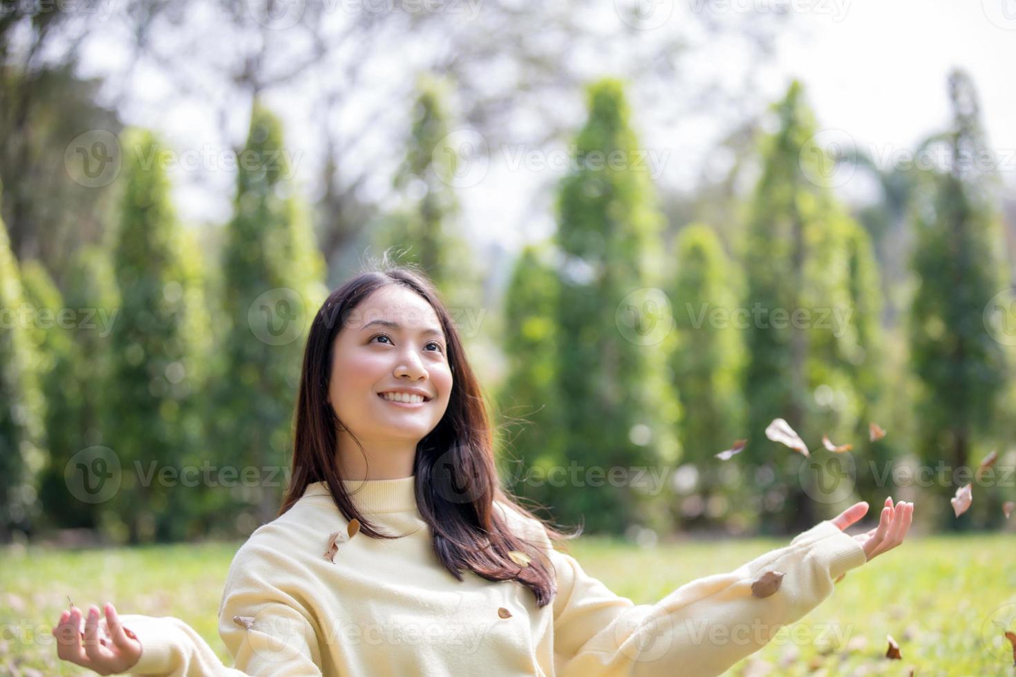 linda mulher asiática sorrindo, garota feliz e vestindo roupas quentes, inverno e outono retrato ao ar livre no parque foto