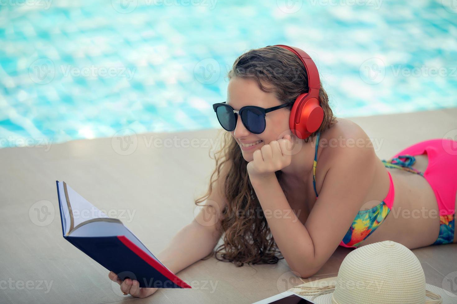 as mulheres usam biquínis, leem livros e ouvem música na piscina recreativa de verão. foto