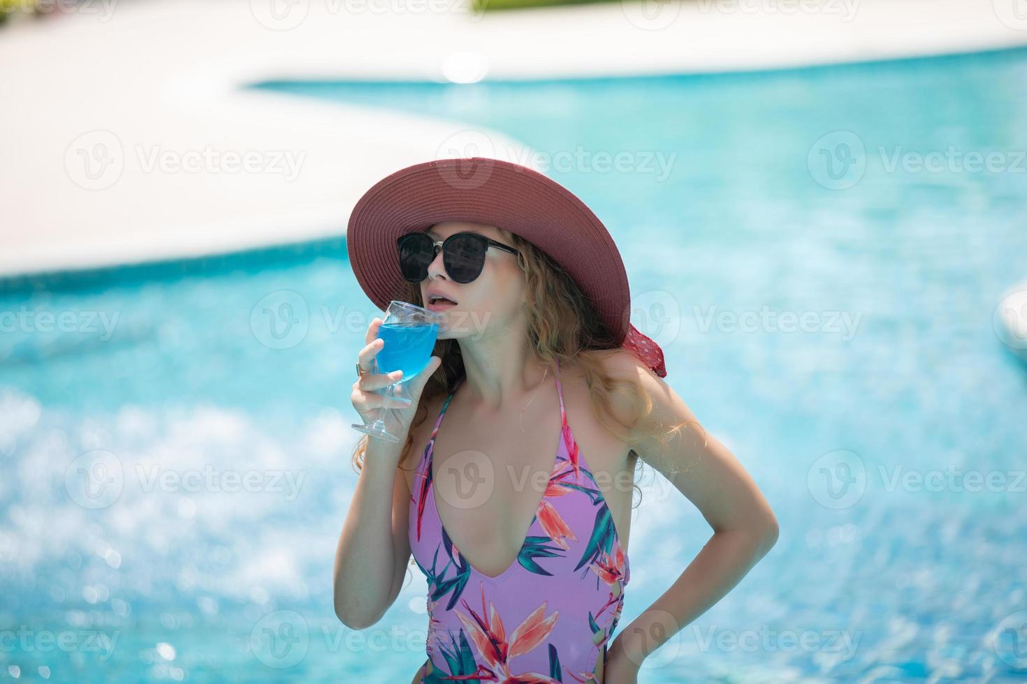 as mulheres usam biquínis e bebem coquetéis no verão quente na piscina. foto