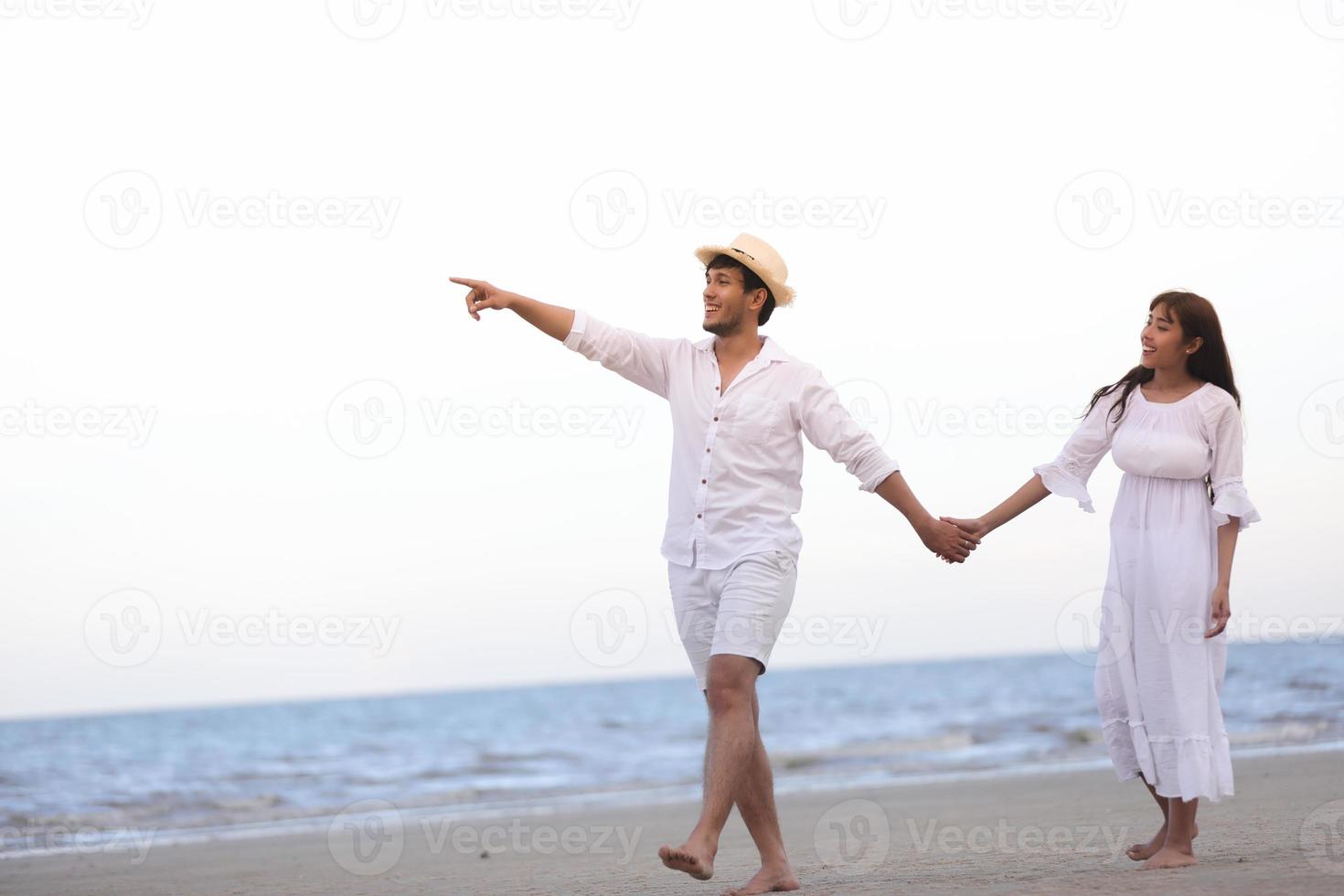 Amante de casais românticos felizes de mãos dadas caminhando na praia foto