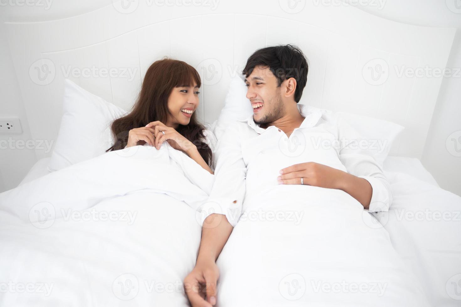 amante de casais deitado na cama felicidade estilo de vida e garota sorridente relaxando na cama branca foto