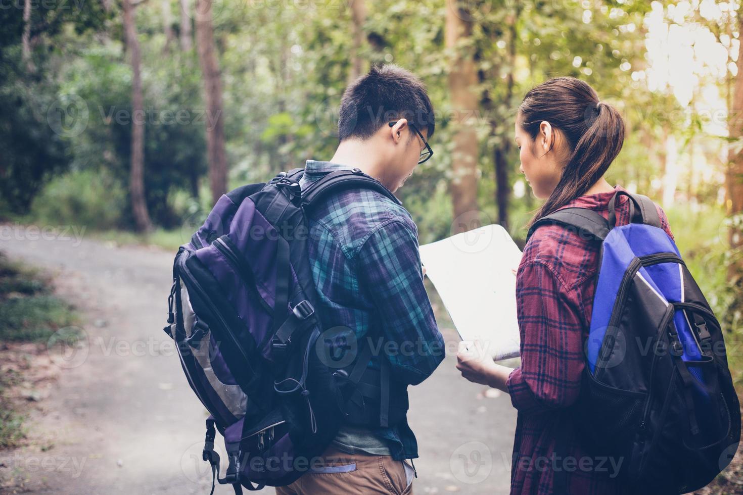 Grupo asiático de jovens caminhando com mochilas de amigos caminhando juntos e olhando o mapa e tirando a câmera fotográfica na estrada e parecendo feliz, relaxe o tempo na viagem do conceito de férias foto