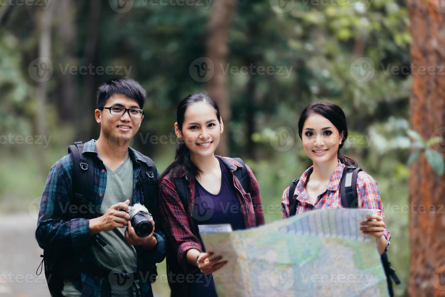 Grupo asiático de jovens caminhando com mochilas de amigos caminhando juntos e olhando o mapa e tirando a câmera fotográfica na estrada e parecendo feliz, relaxe o tempo na viagem do conceito de férias foto