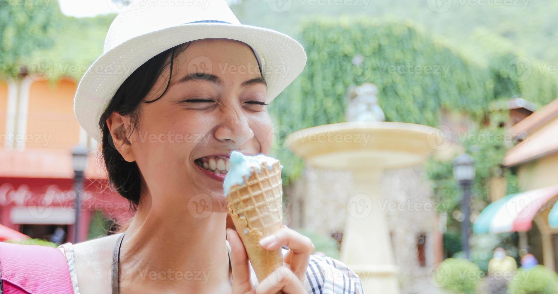 linda mulher segurando e tomando sorvete nas férias de verão foto