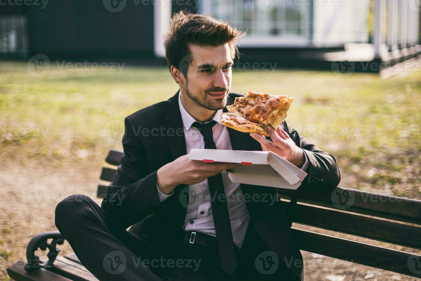 elegante homem de negocios goza comendo pizza em dele almoço pausa enquanto sentado ao ar livre.toned imagem. foto