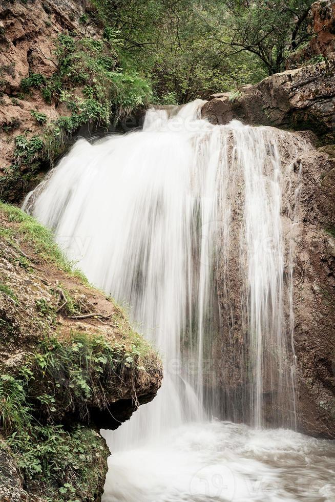 bela cachoeira na montanha capturada com desfoque de movimento foto