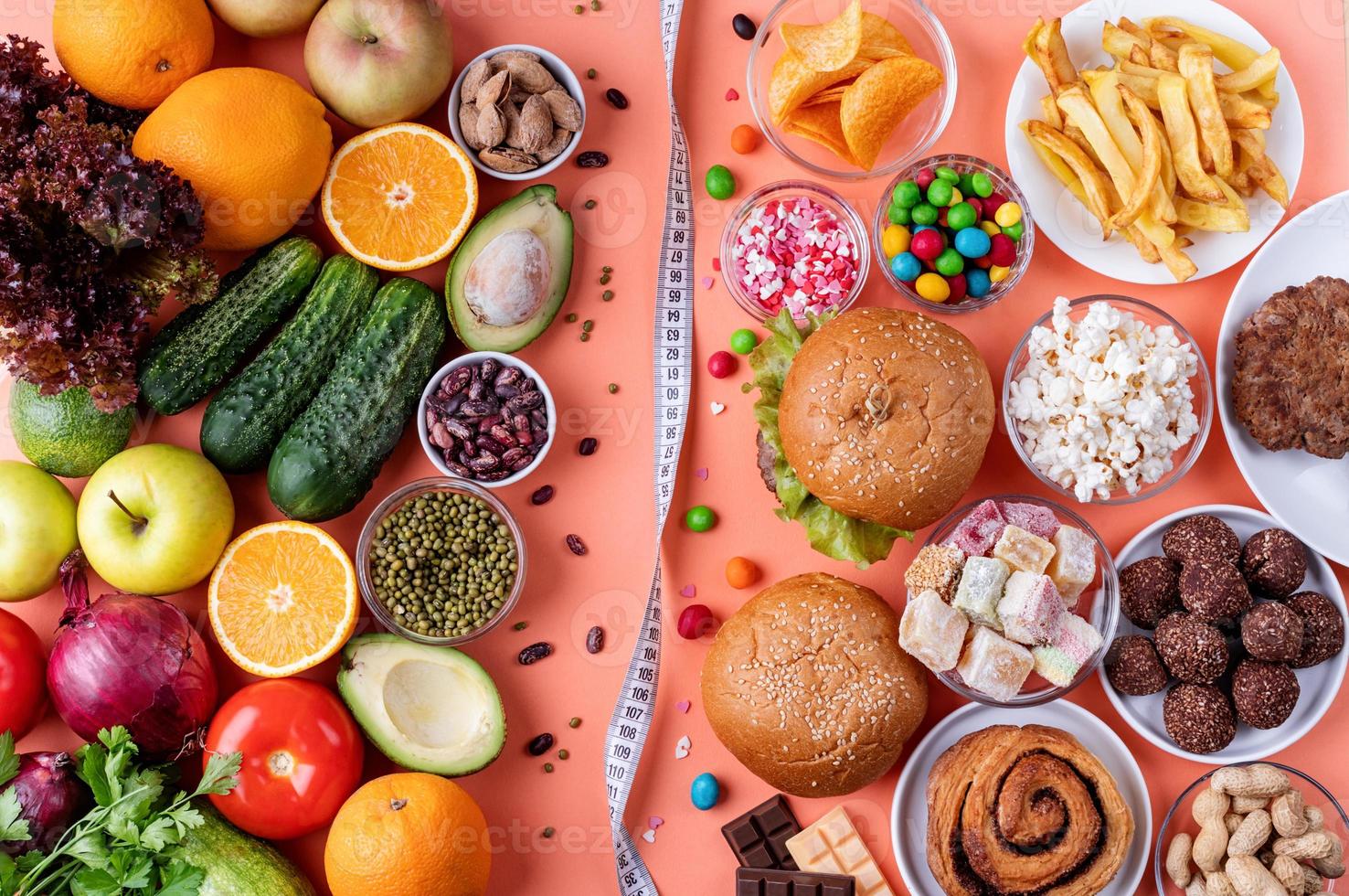 frutas e vegetais vs doces e fast food vista superior plana sobre fundo laranja foto