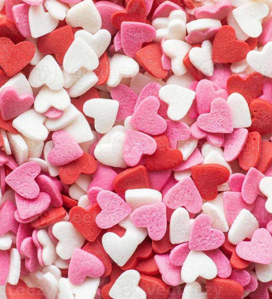 formas de coração vermelho branco e rosa polvilham o fundo foto
