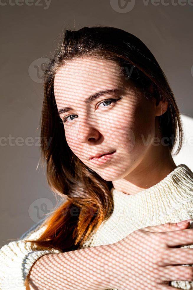 retrato de uma bela jovem com um padrão de sombra no rosto e corpo foto