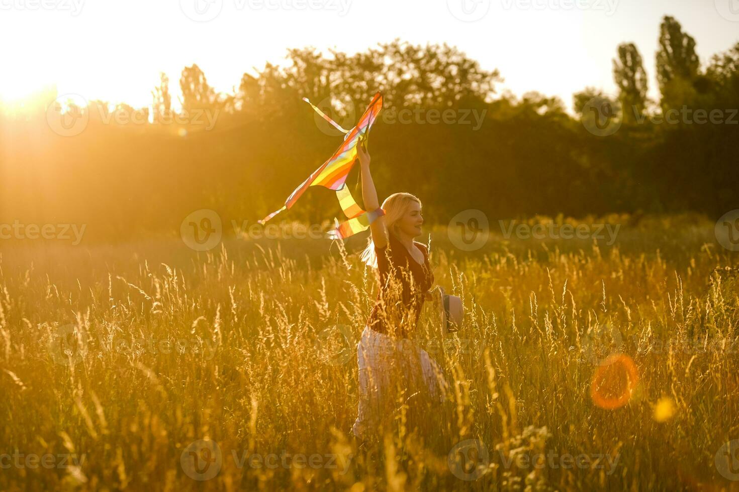 retrato do uma jovem e despreocupado mulher lançamento pipa em a campo Verde. conceito do ativo estilo de vida dentro natureza foto