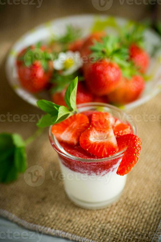 doce caseiro iogurte com morango geléia e fresco morangos dentro uma vidro copo foto