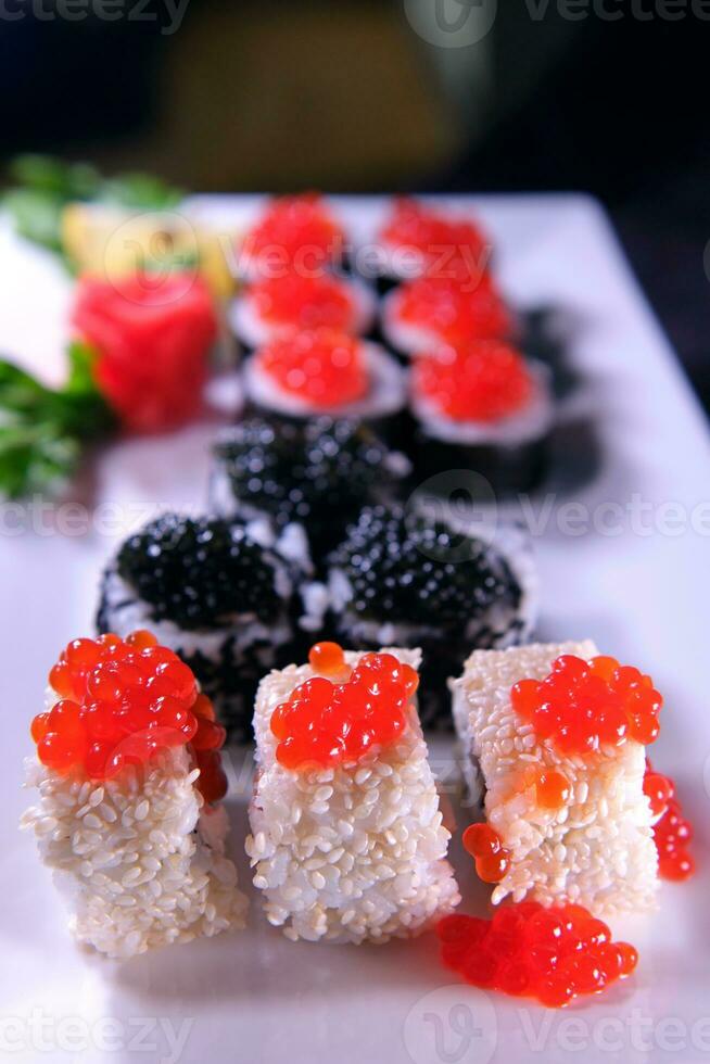 três tipos do Sushi rolos com branco e Preto sésamo sementes com Preto peixe-remo caviar, vermelho amigo salmão caviar e Rosa salmão em 1 placa. delicioso comida, lindo apresentação. foto