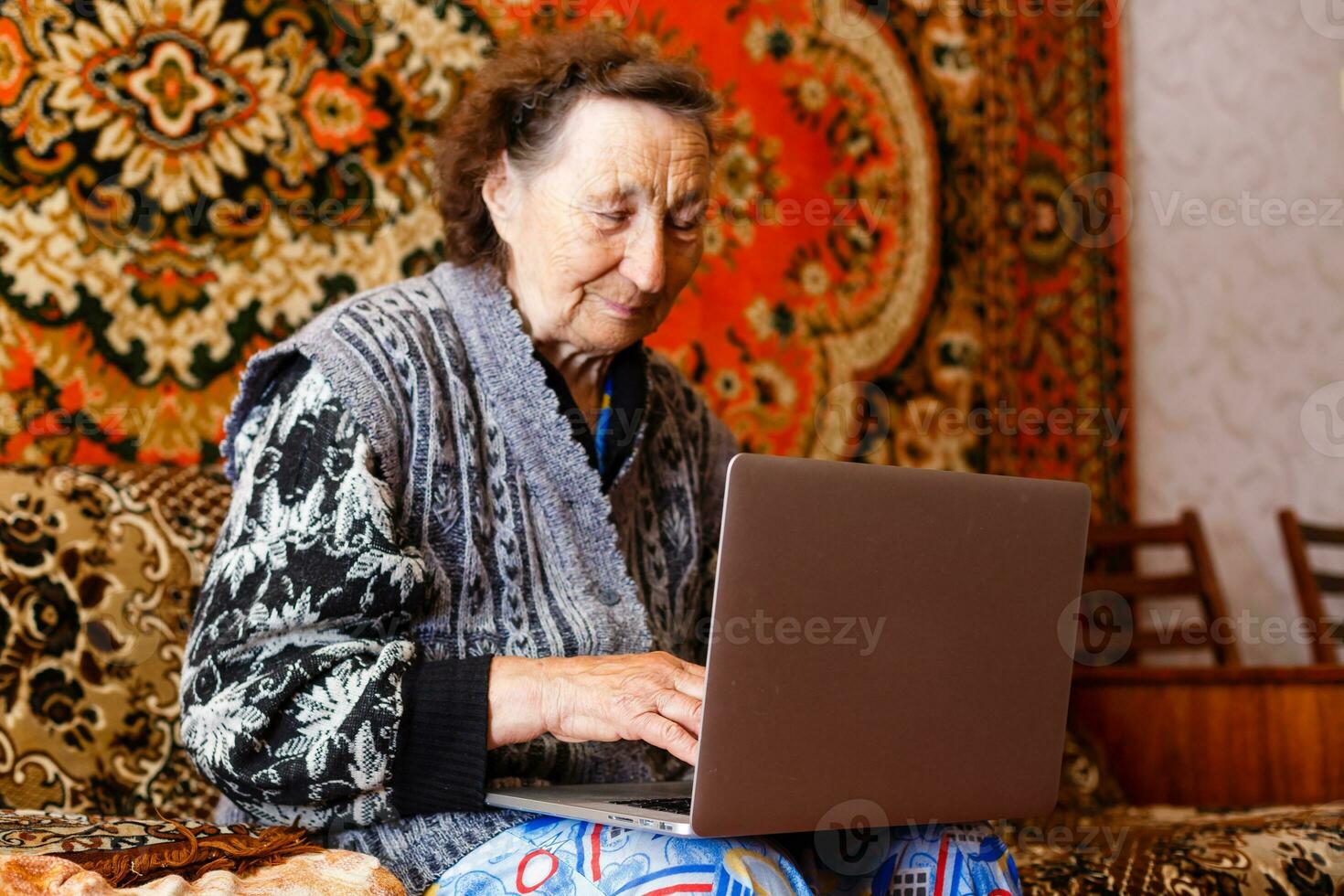 mais velho mulher usando uma computador portátil computador às casa foto