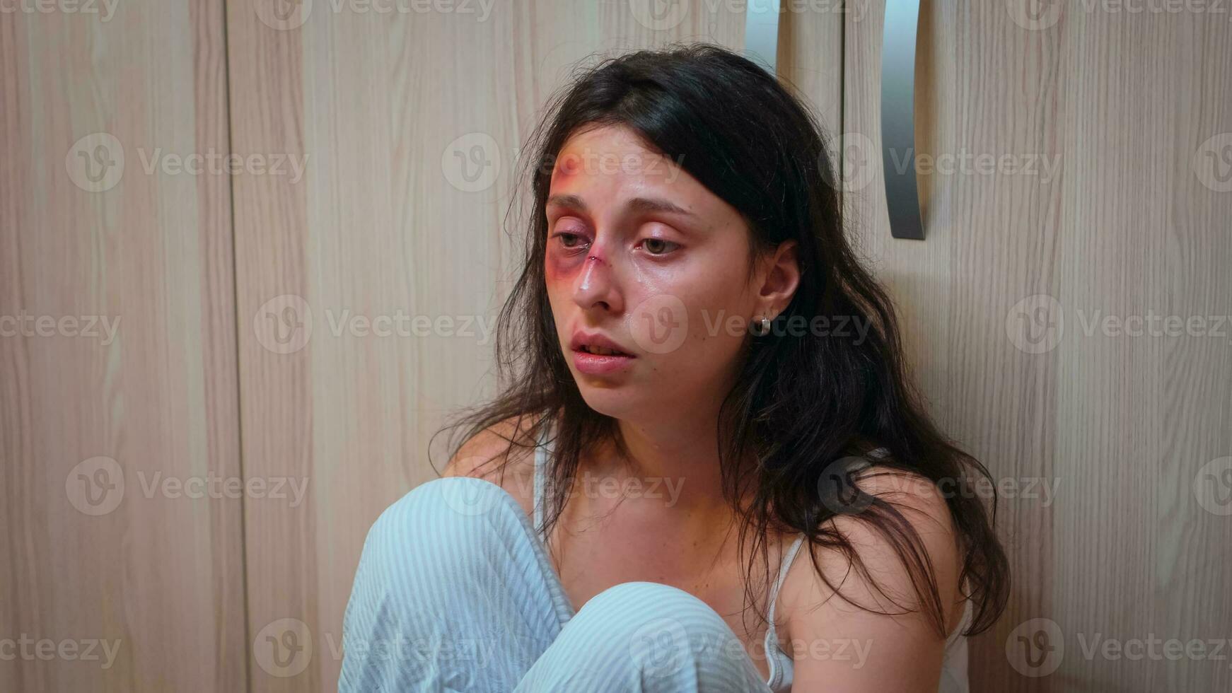 espancado mulher, vítima do doméstico violência sentado em a chão. alcoólico agressivo marido abusando ferindo apavorado desamparado, com medo, espancado e em pânico esposa vivo dentro terror e pressão. foto