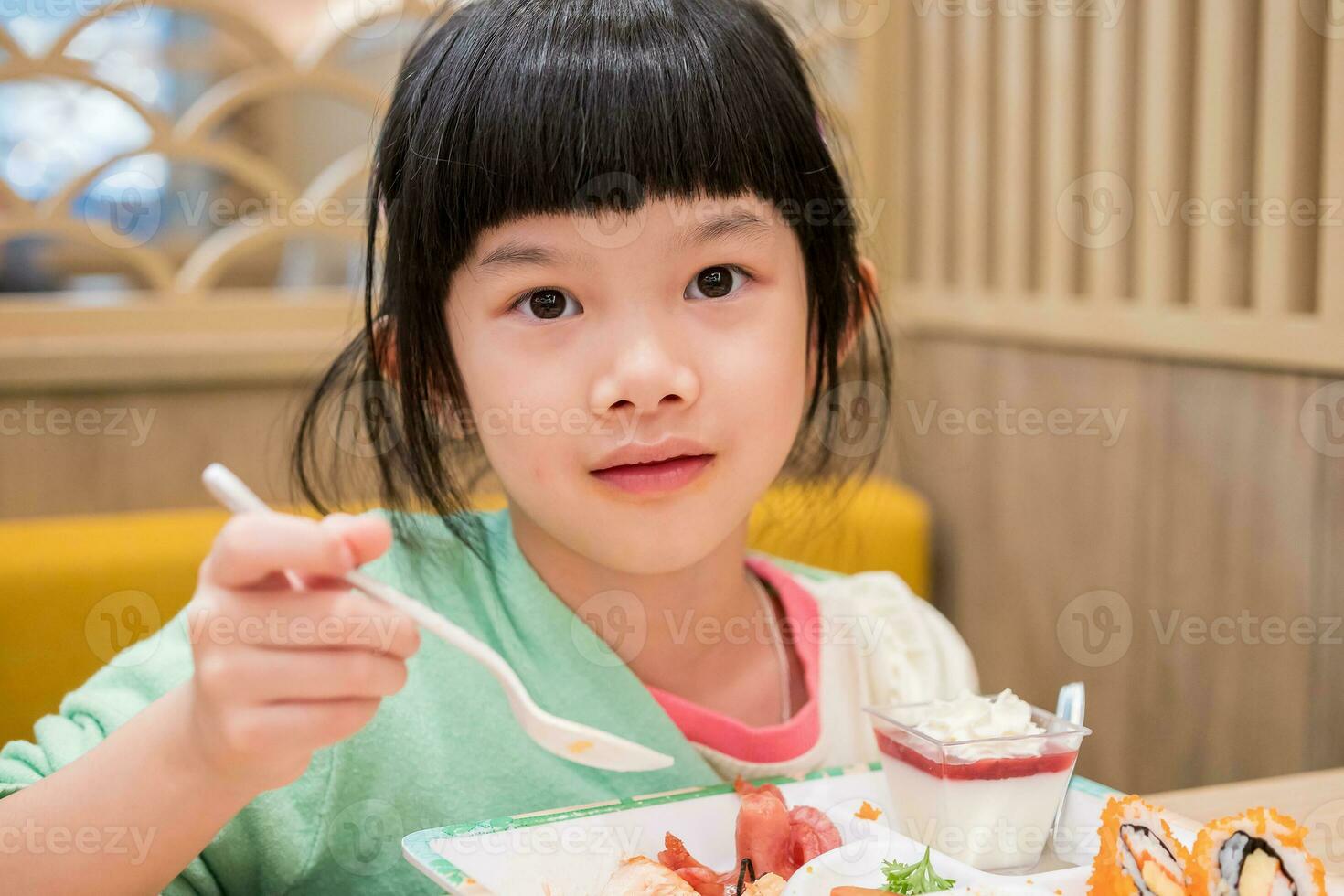 fofa pequeno ásia criança menina comendo Comida foto