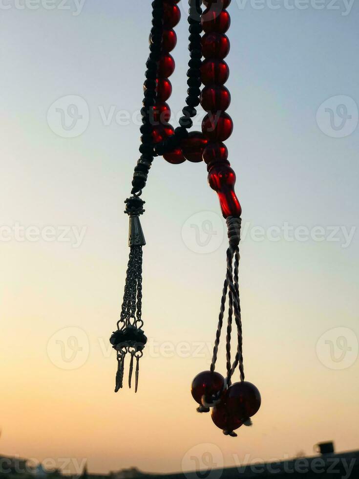 uma colar com vermelho miçangas suspensão a partir de uma parede foto