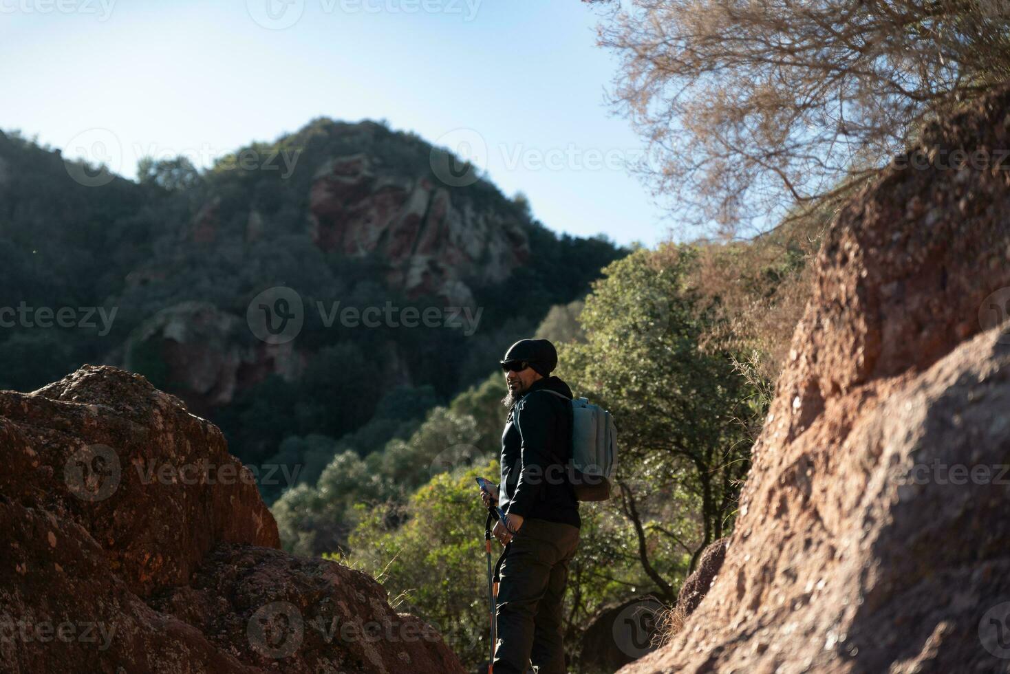 meia idade homem contempla a paisagens do a garraf natural parque enquanto caminhando ao longo a trilhas do uma montanha. foto