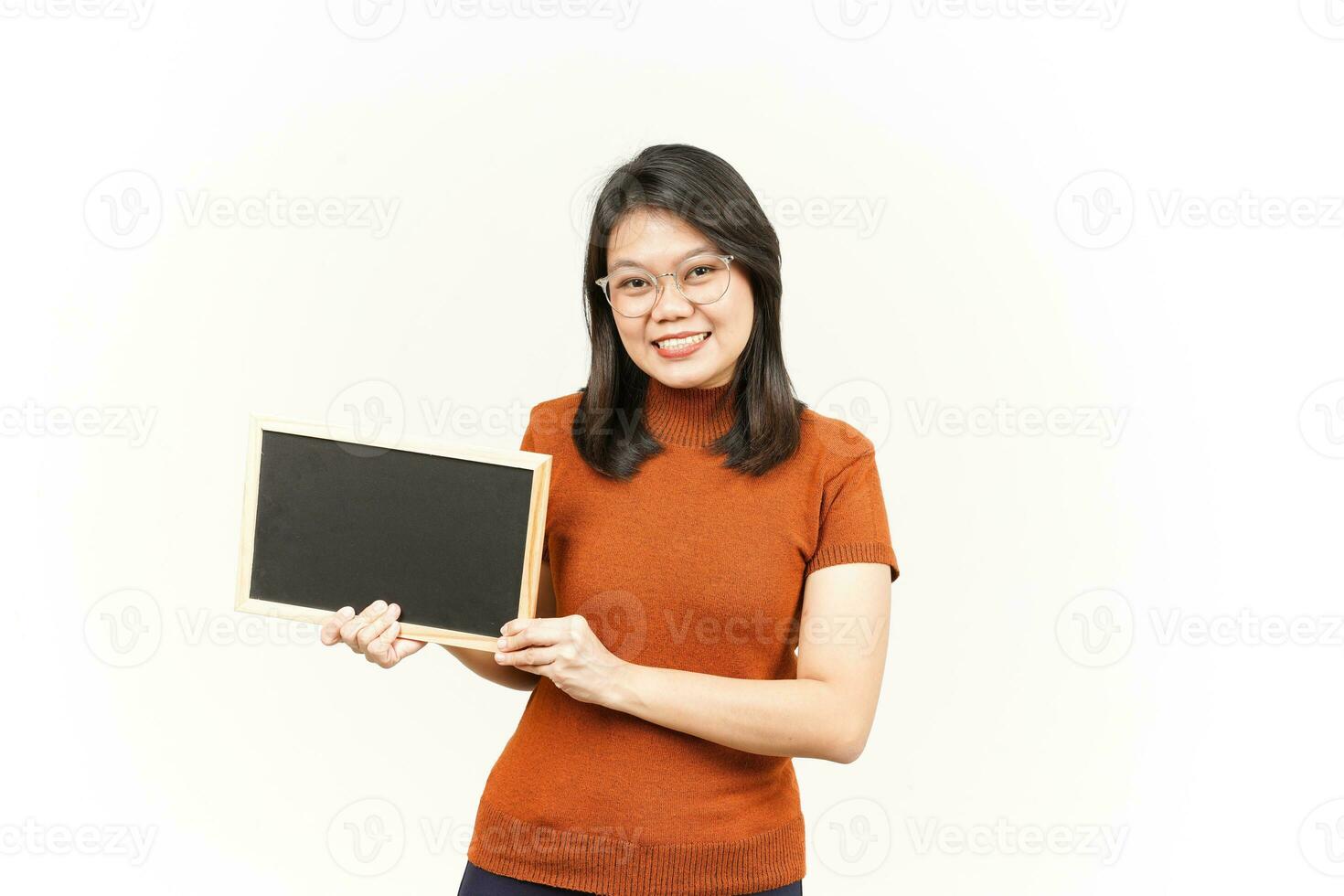 mostrando, apresentando e segurando o quadro-negro em branco da bela mulher asiática isolada no branco foto