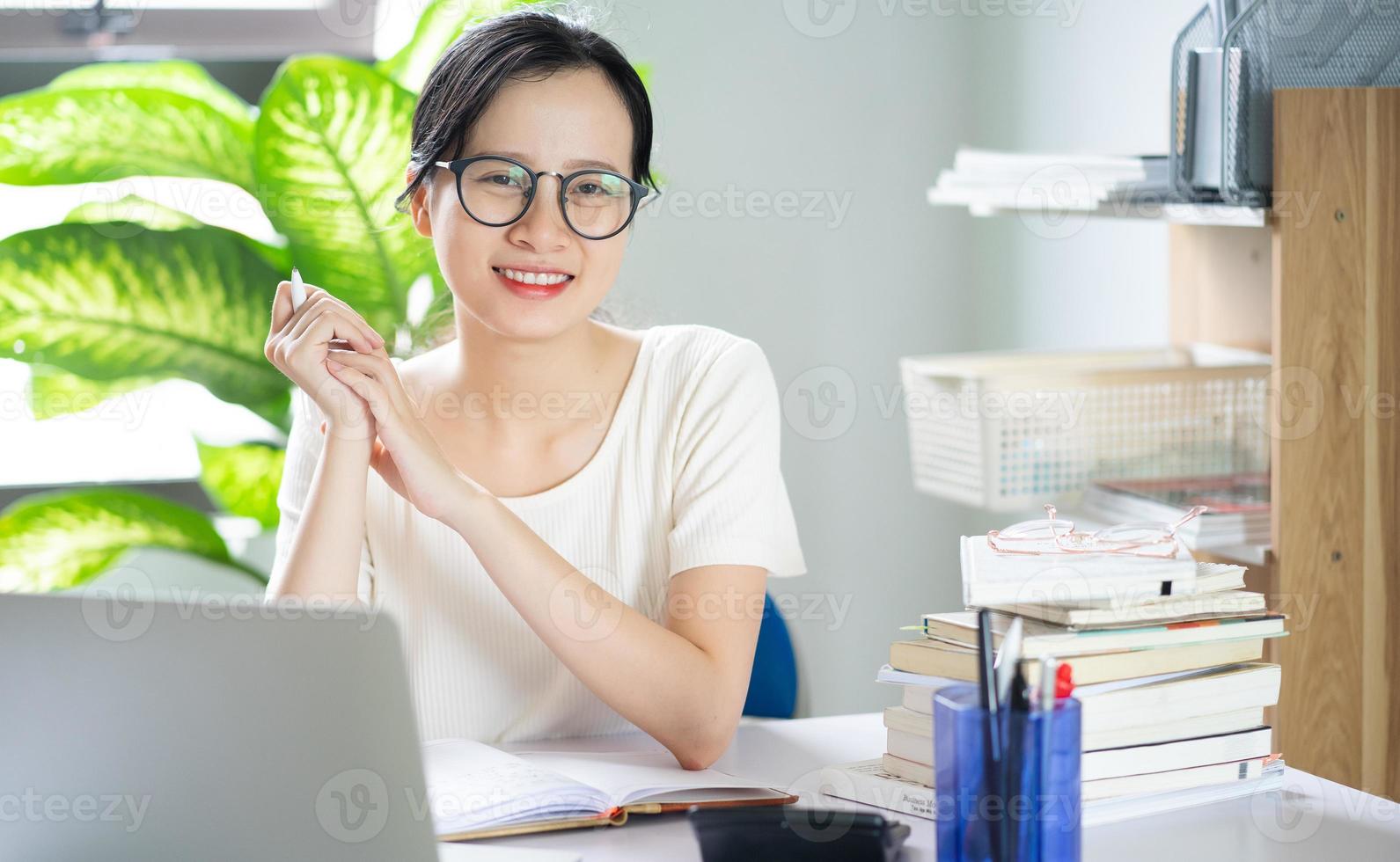 jovem asiática fazendo lição de casa foto