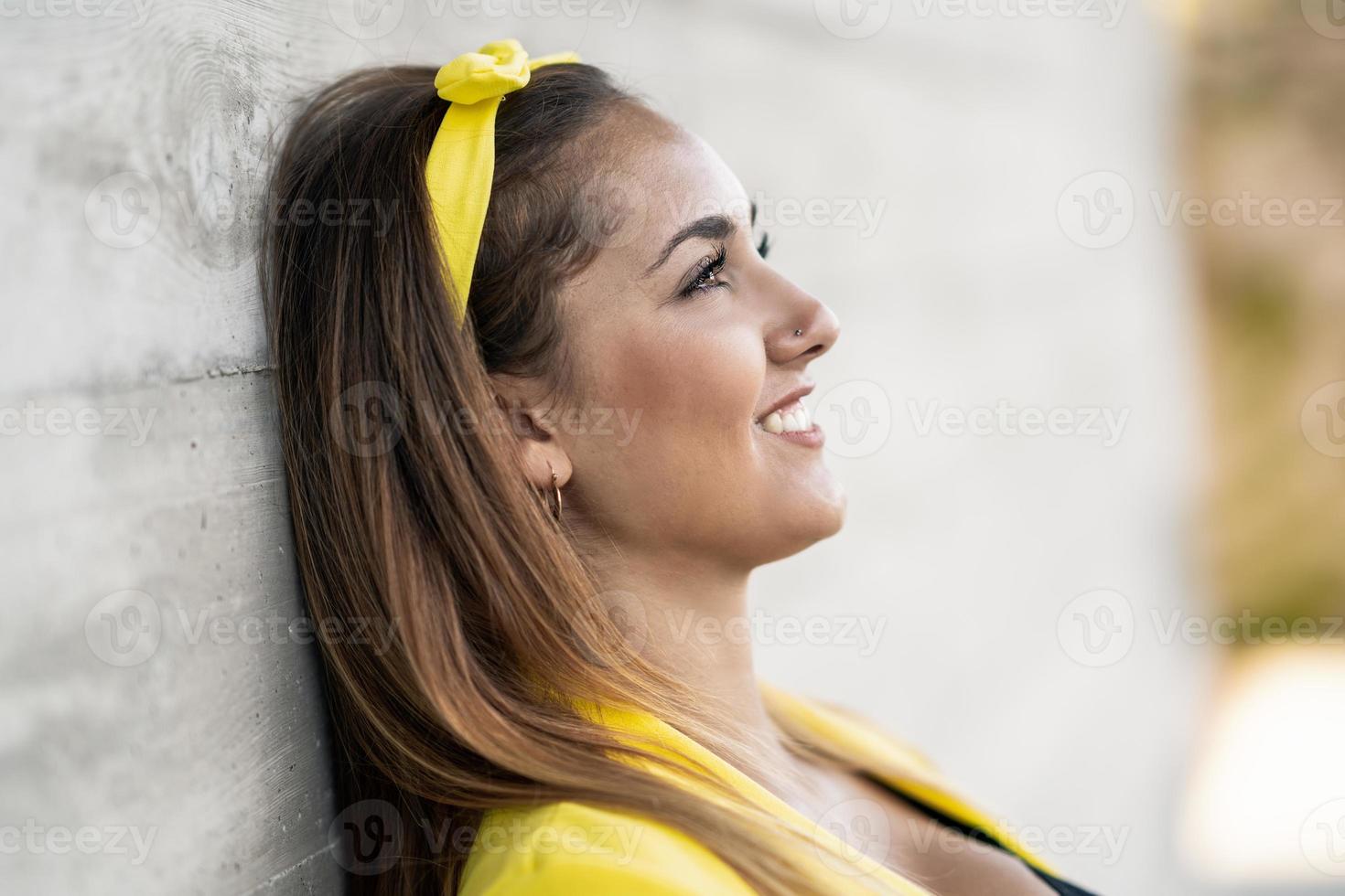 jovem vestindo uma jaqueta amarela e tiara sorrindo. foto