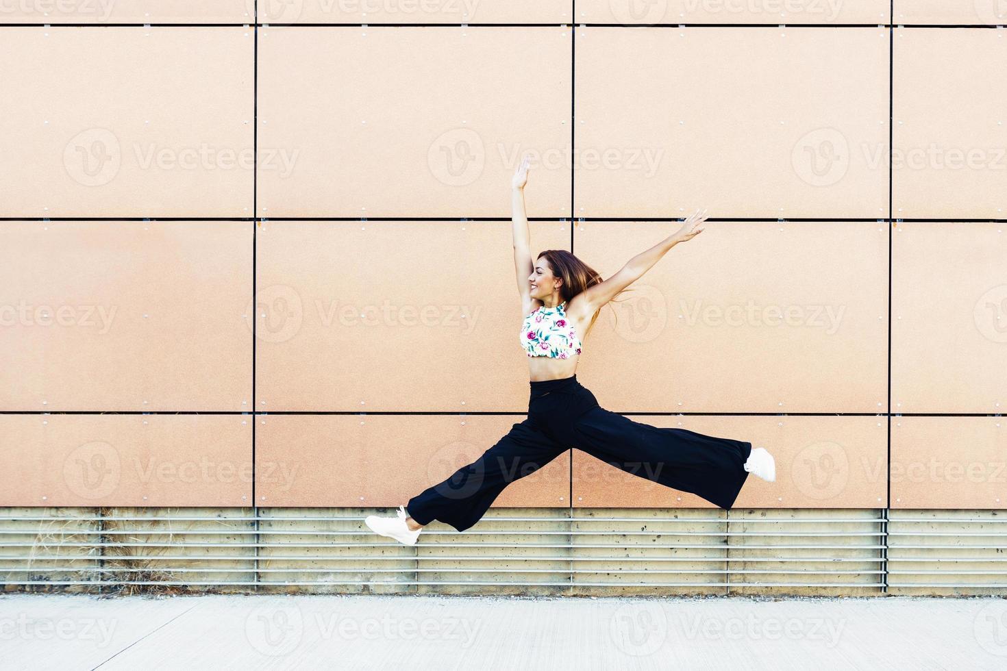 jovem feliz pulando em meio urbano foto