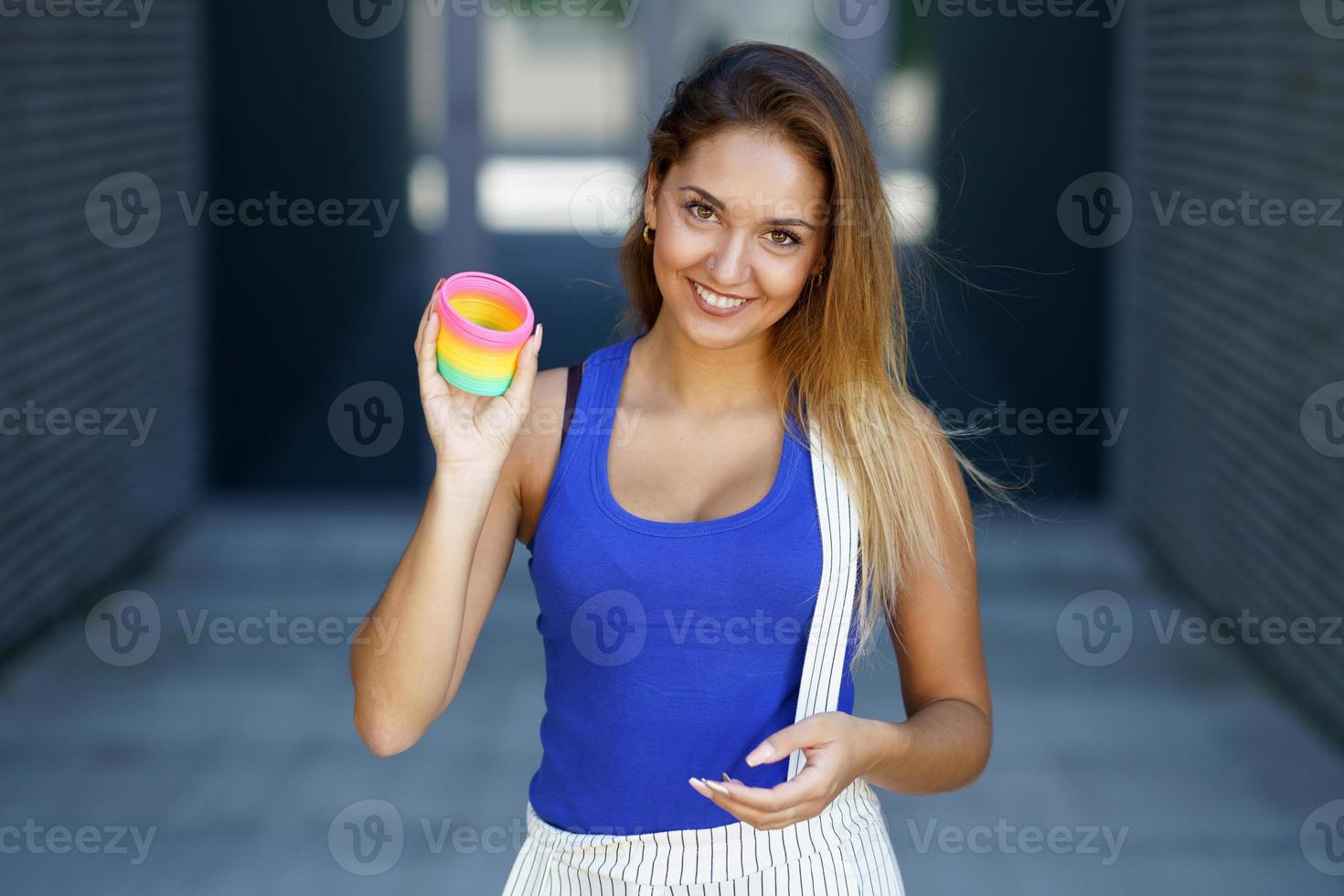menina brincando com um brinquedo colorido de primavera ao ar livre foto