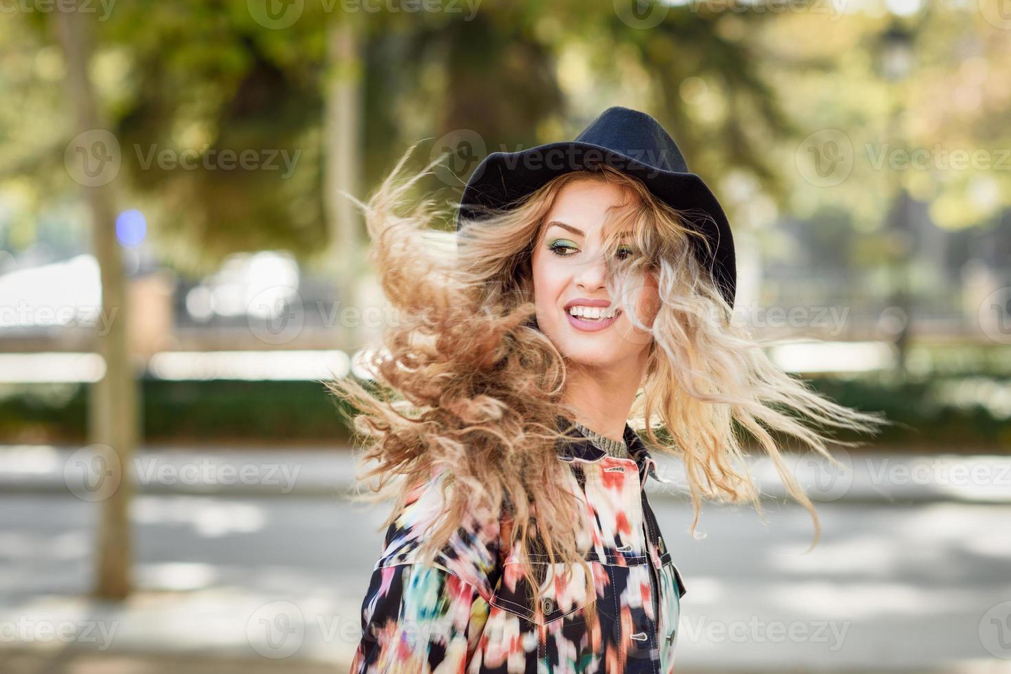 jovem mulher com cabelo esvoaçante vestindo jaqueta e ha foto