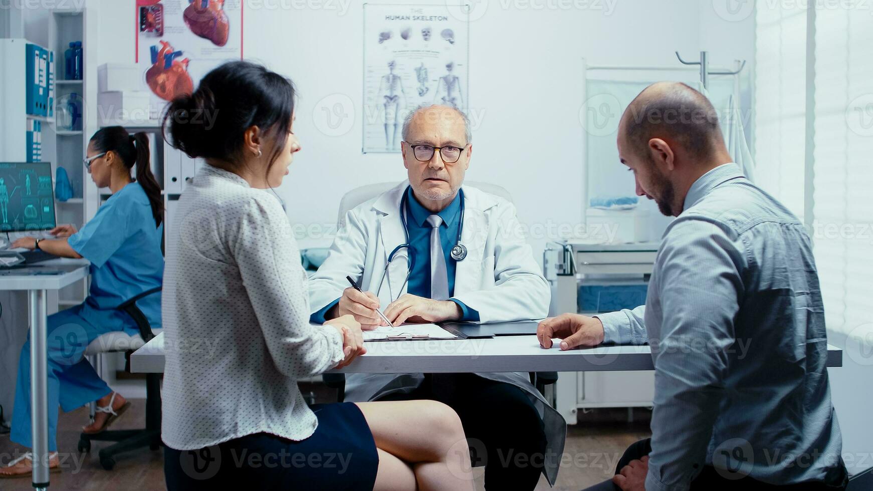 jovem casal falando com Senior médico dentro moderno privado clínica. família planejamento especialista. pessoas dentro moderno privado hospital ou clínica, remédio e saúde Cuidado problemas. foto