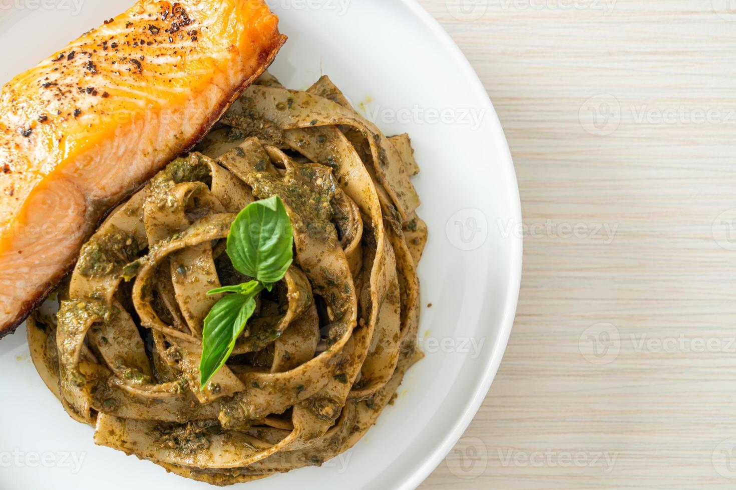 macarrão espaguete pesto fettuccine com filé de salmão grelhado foto