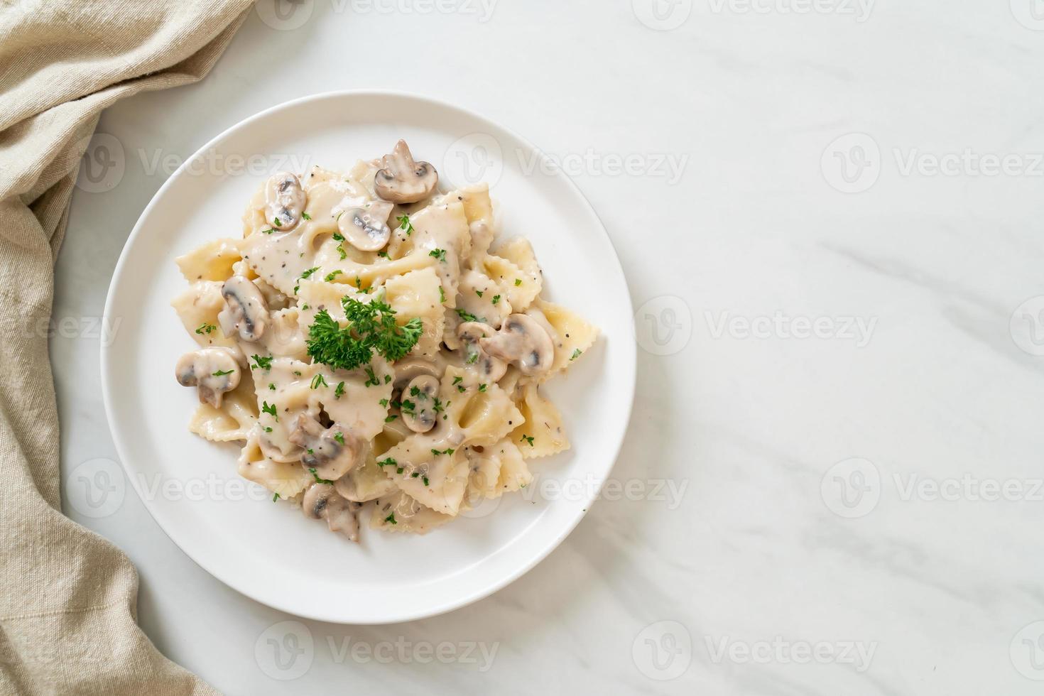 macarrão farfalle com molho de creme de cogumelos branco foto