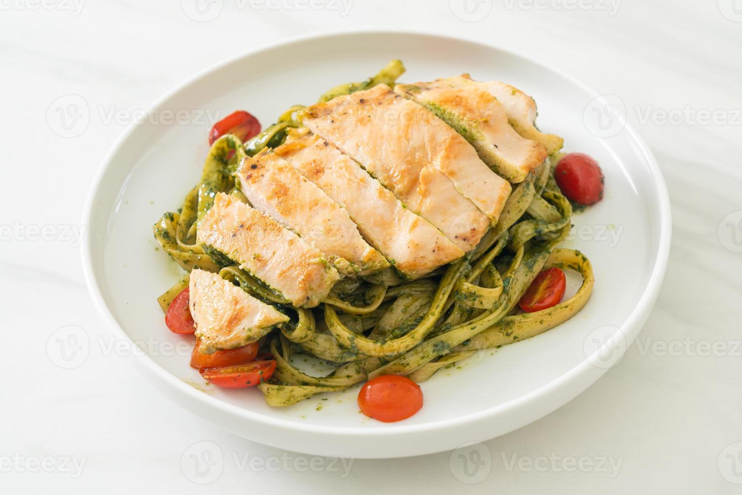 macarrão fettuccine espaguete ao molho pesto com frango grelhado foto