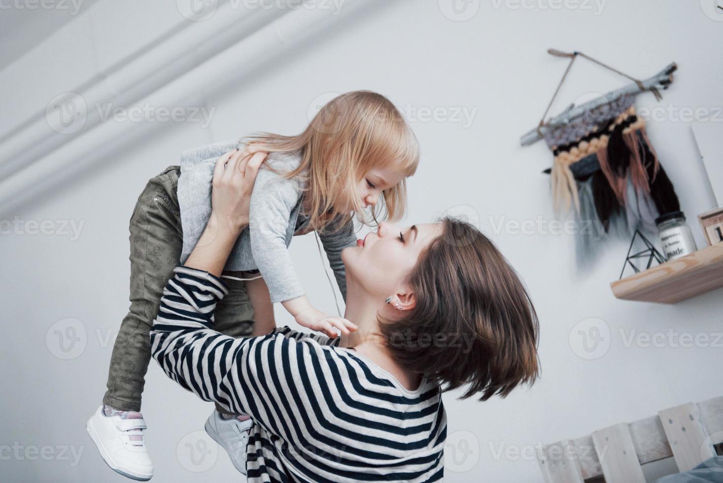 família amorosa feliz. mãe e filha menina brincando e se abraçando foto