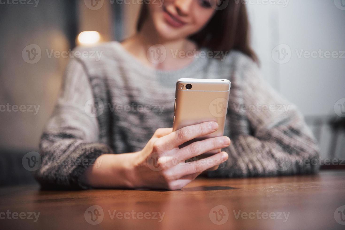 uma garota atraente com longos cabelos negros pondera sobre um novo projeto durante uma pausa para o café, sentada à mesa de uma cafeteria foto