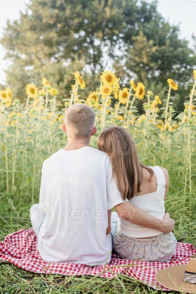 jovem casal se abraçando em uma toalha de piquenique foto