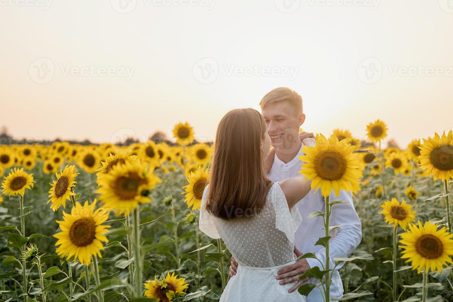 lindo casal se divertindo em campos de girassóis foto