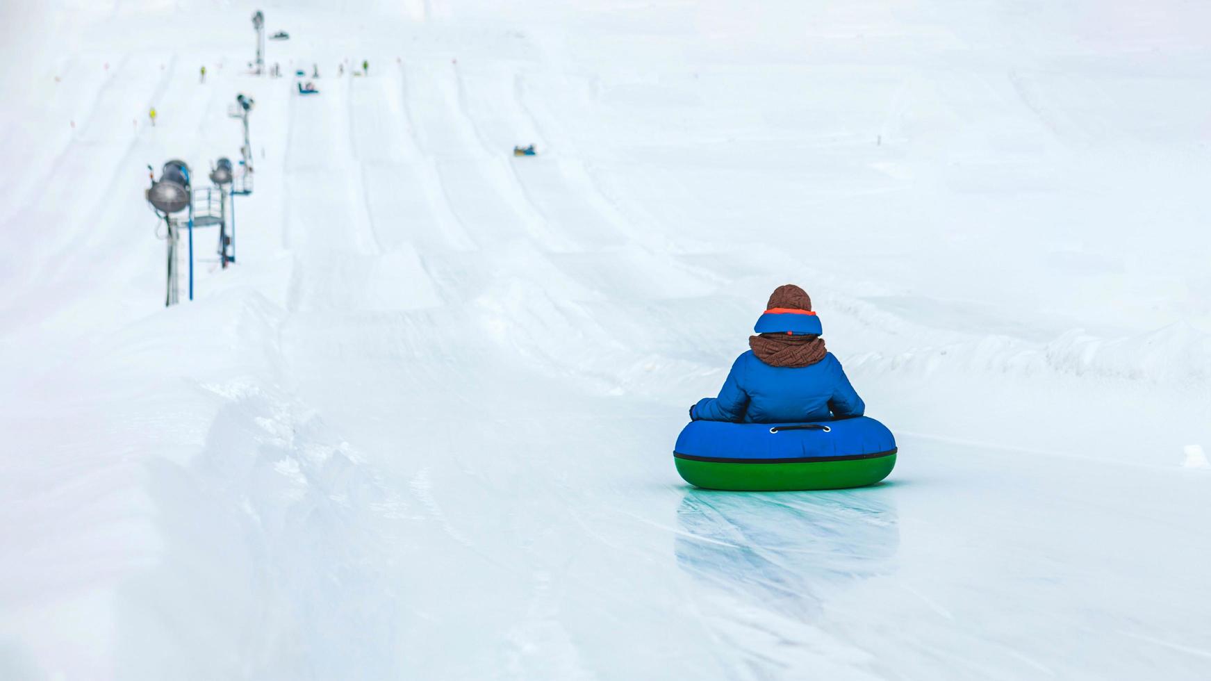 pessoas andando de tubo de neve no parque de inverno foto