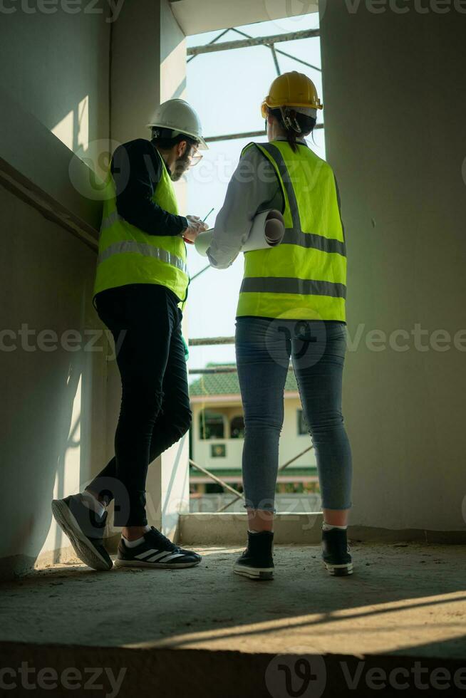 engenheiro e arquiteto trabalhando em a construção site, dupla verificação planos e processo. foto