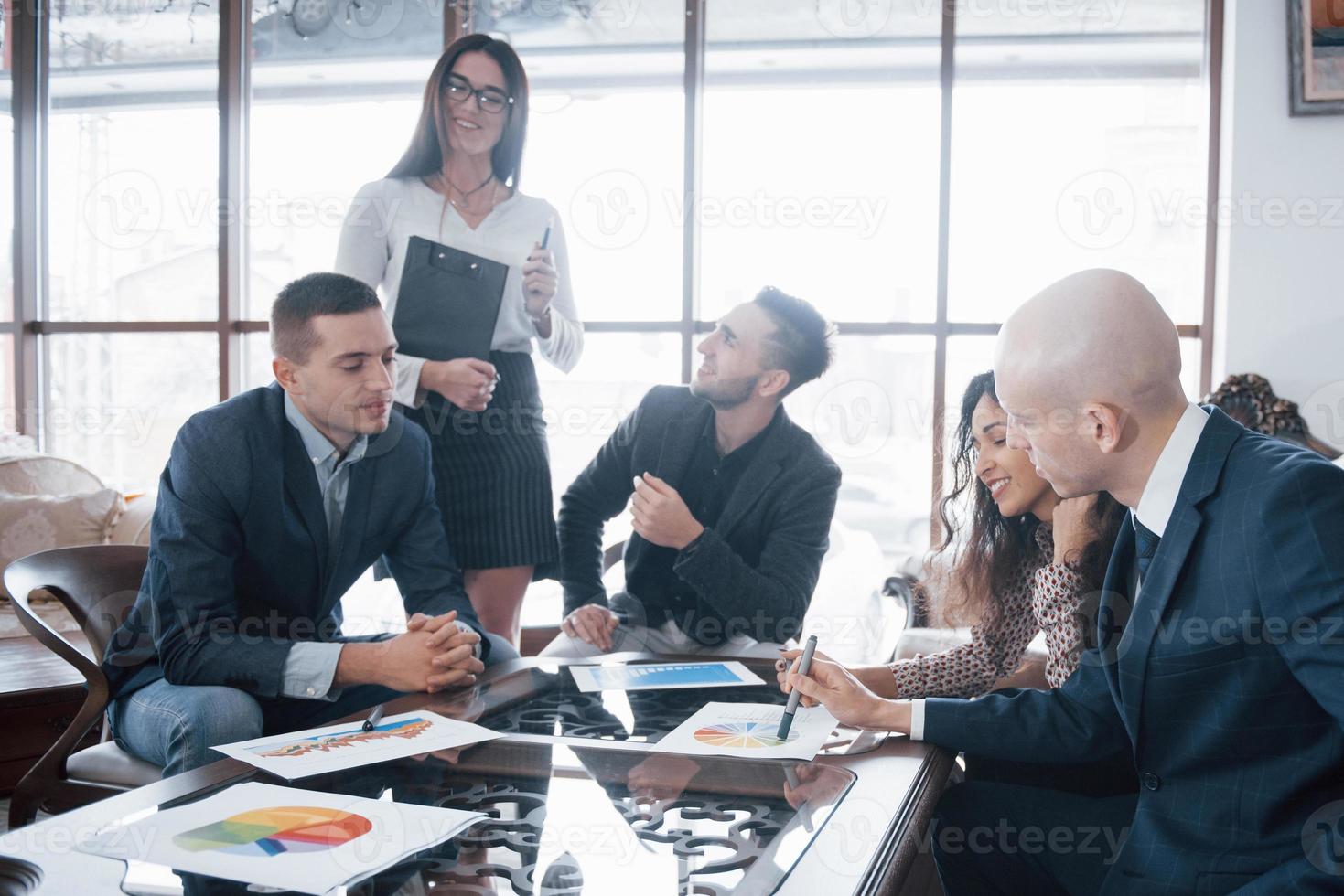 jovem equipe de colegas de trabalho discutindo grandes negócios no moderno escritório de coworking. conceito de trabalho em equipe foto