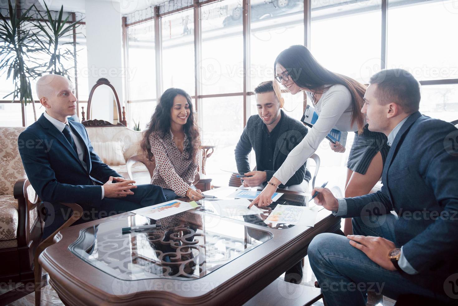 jovem equipe de colegas de trabalho discutindo grandes negócios no moderno escritório de coworking. conceito de trabalho em equipe foto