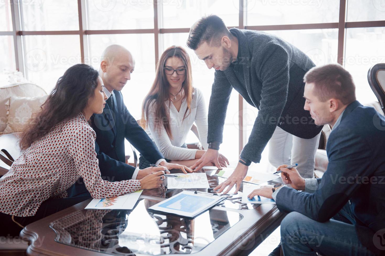 jovem equipe de colegas de trabalho discutindo grandes negócios no moderno escritório de coworking. conceito de trabalho em equipe foto